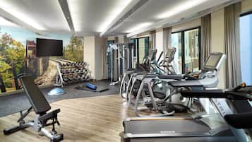 Ein Fitnessraum eines Hotels mit Laufbändern, Crosstrainern und Kurzhanteln.