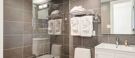 Un baño moderno con inodoro, lavamanos y espejo.