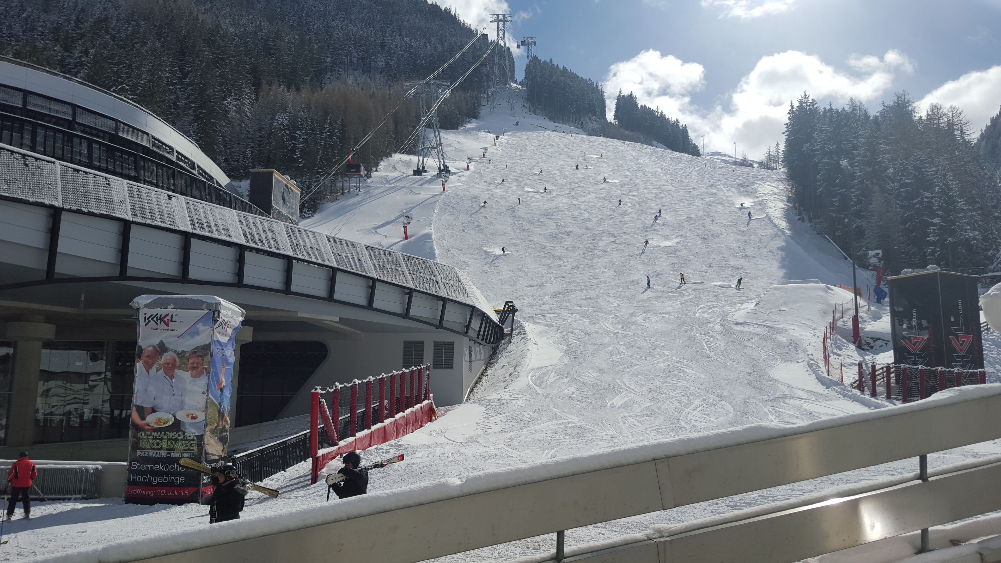 A ski slope with a lift station and a building with a sign.