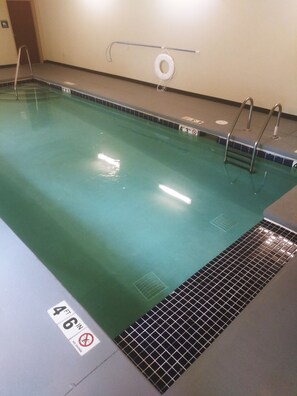 Une piscine avec une indication de profondeur (1,37 mètre), une échelle et un couvercle d’évacuation.