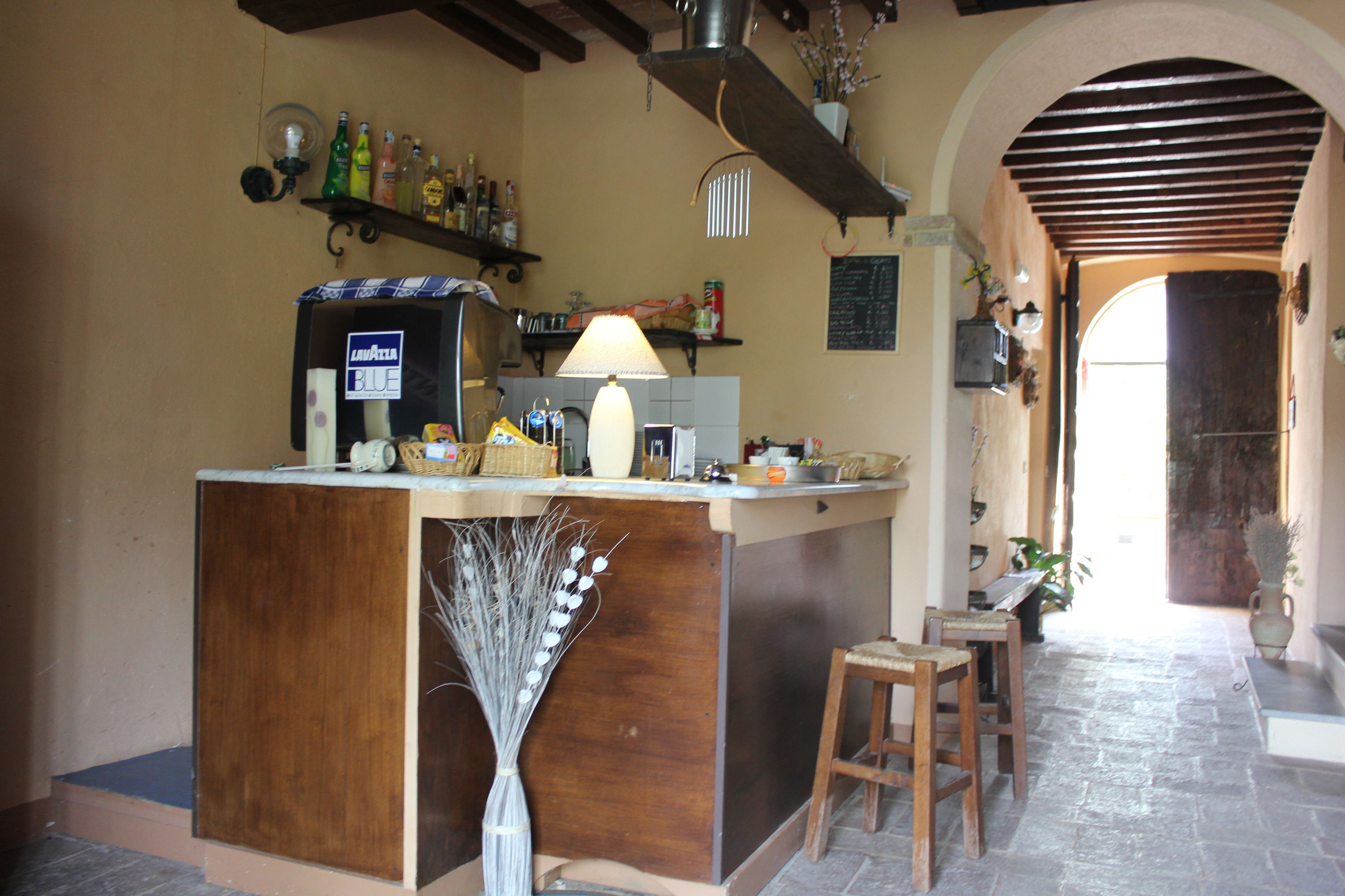 A kitchen with a bar area, wooden stools, and a decorative vase.