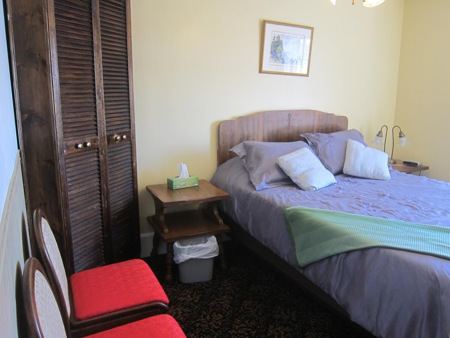 Ein Schlafzimmer mit Bett, Nachttisch und Stuhl.