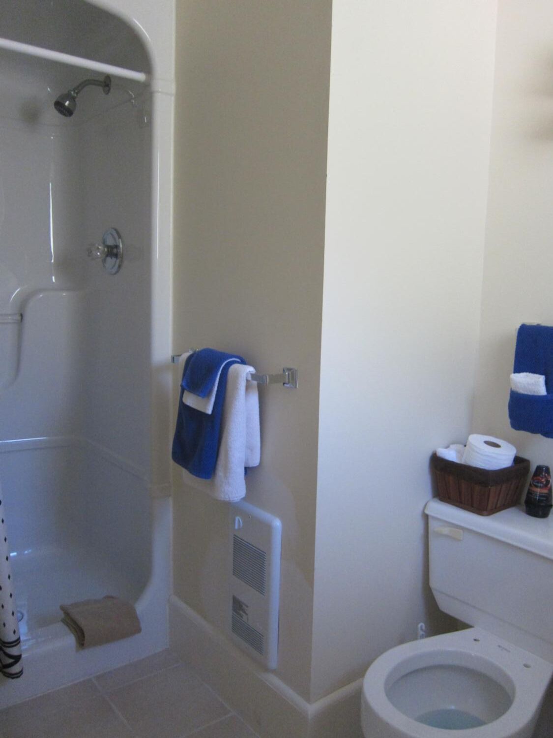 A bathroom with a bathtub, toilet, and a towel rack.