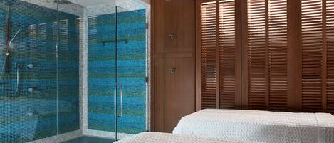 A modern bathroom with a glass-enclosed shower, wooden sliding doors, and a ceiling with a floral design.
