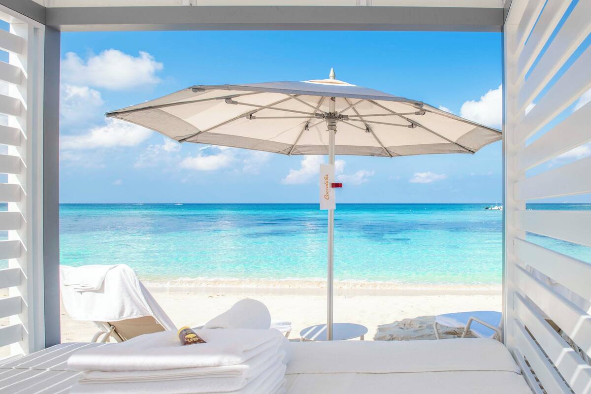 on the beach, white sand, beach cabanas, sun-loungers