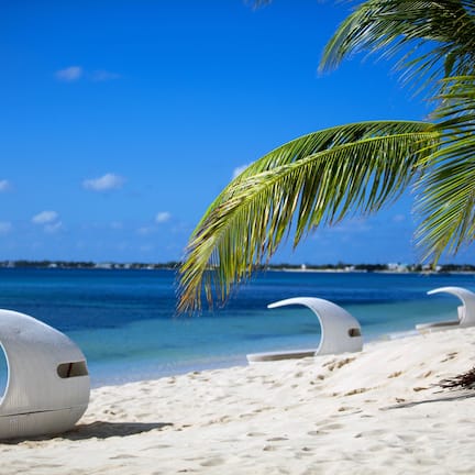 On the beach, white sand, beach cabanas, sun loungers