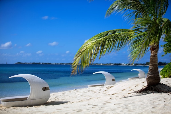 On the beach, white sand, beach cabanas, sun loungers