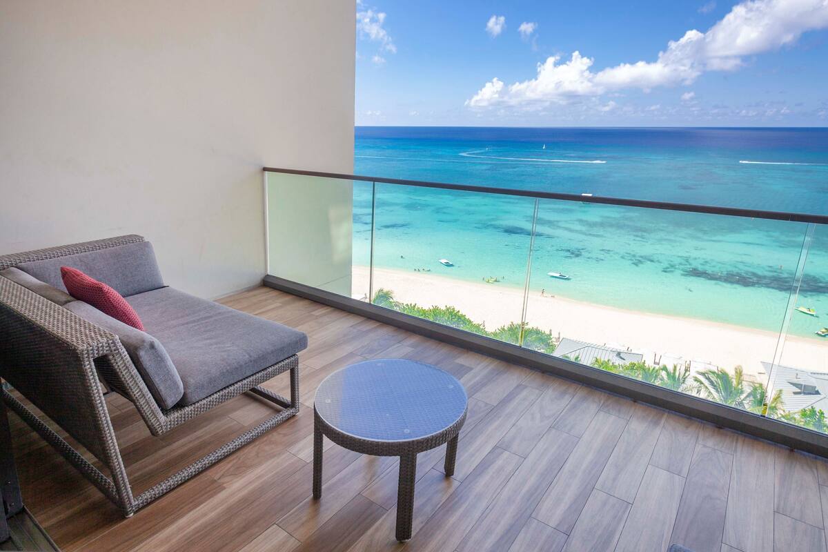 A balcony with a view of a beach and ocean.