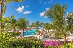 Una piscina al aire libre, camas de piscina con cargo, sombrillas
