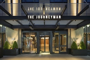 The entrance of The Journeyman hotel with a revolving door, glass facade, and number 310.