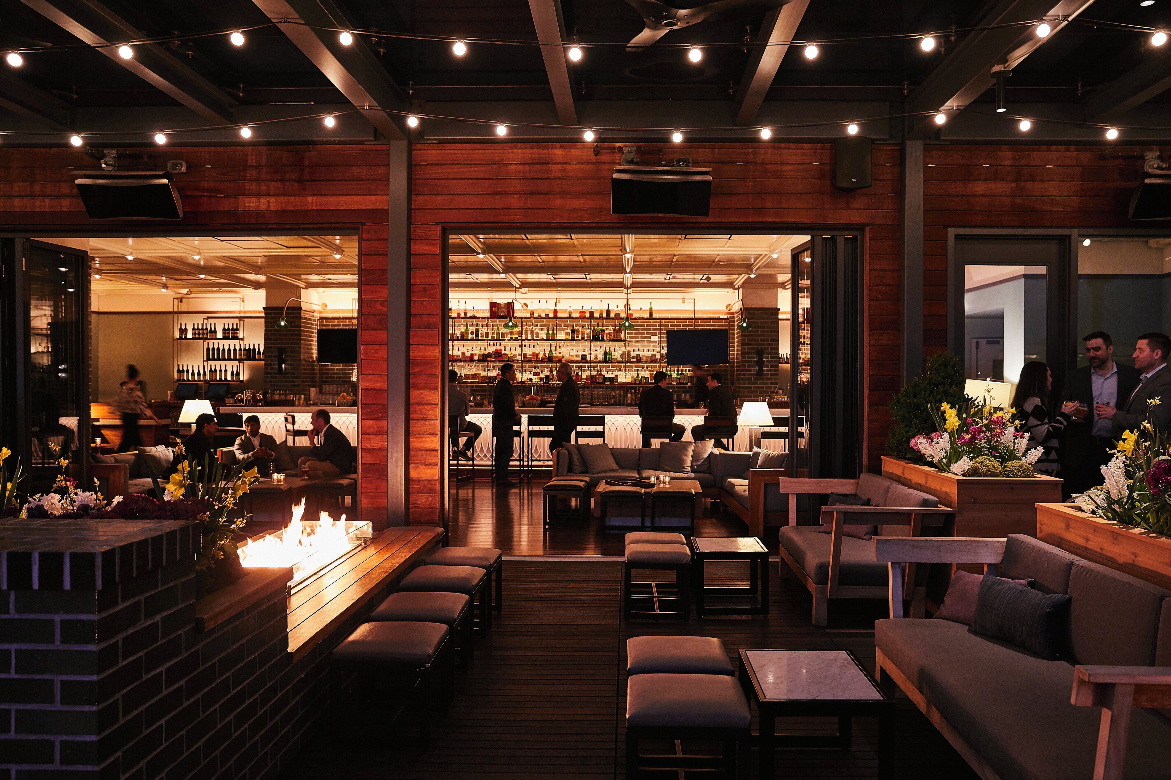 A bar area with seating and a fireplace.