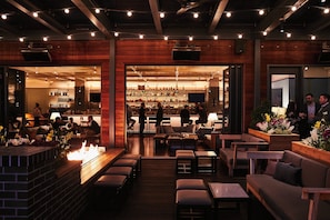 A bar area with seating and a fireplace. - Kimpton Journeyman Hotel by IHG (Milwaukee)