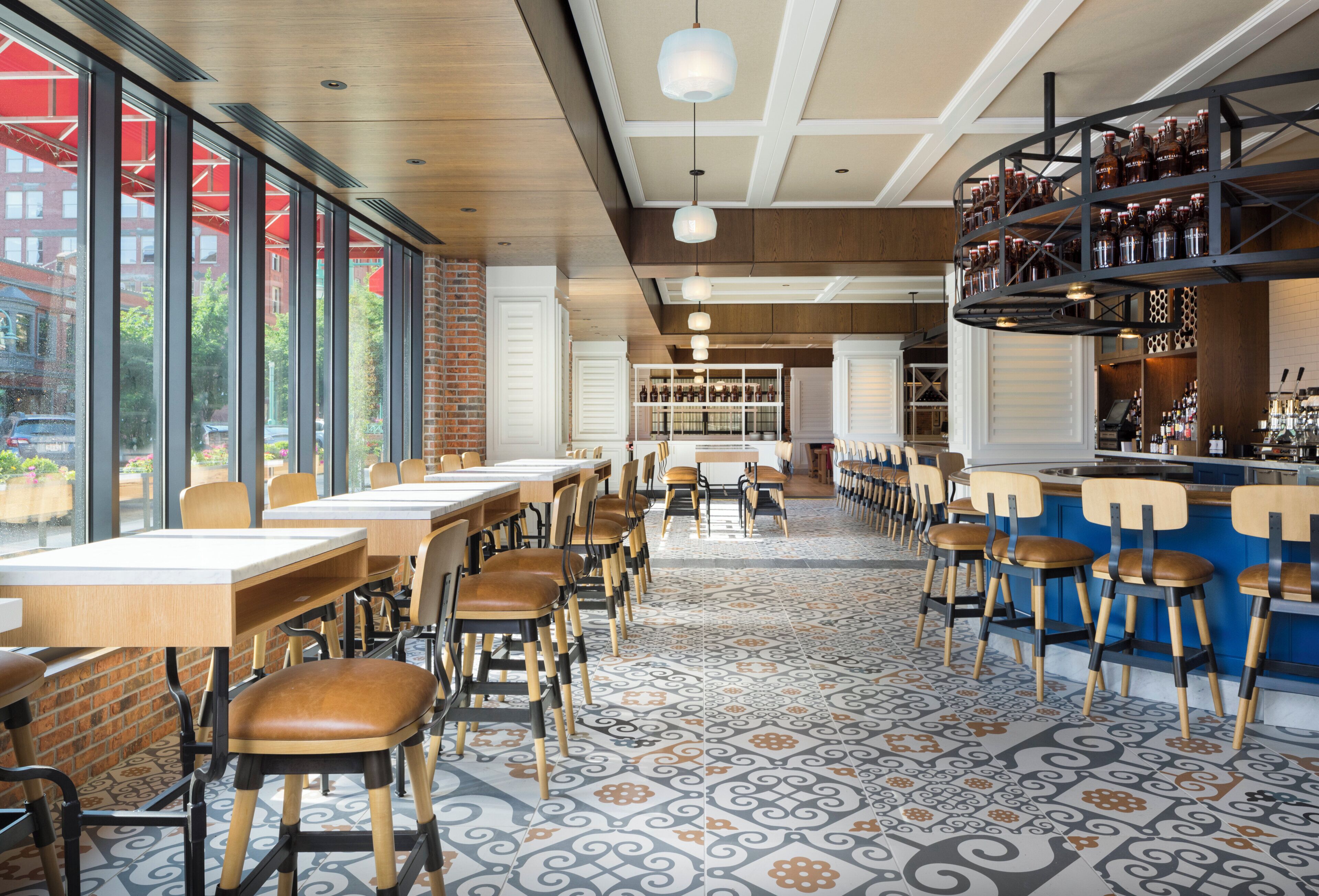 A restaurant interior with high tables, chairs, and a bar area.