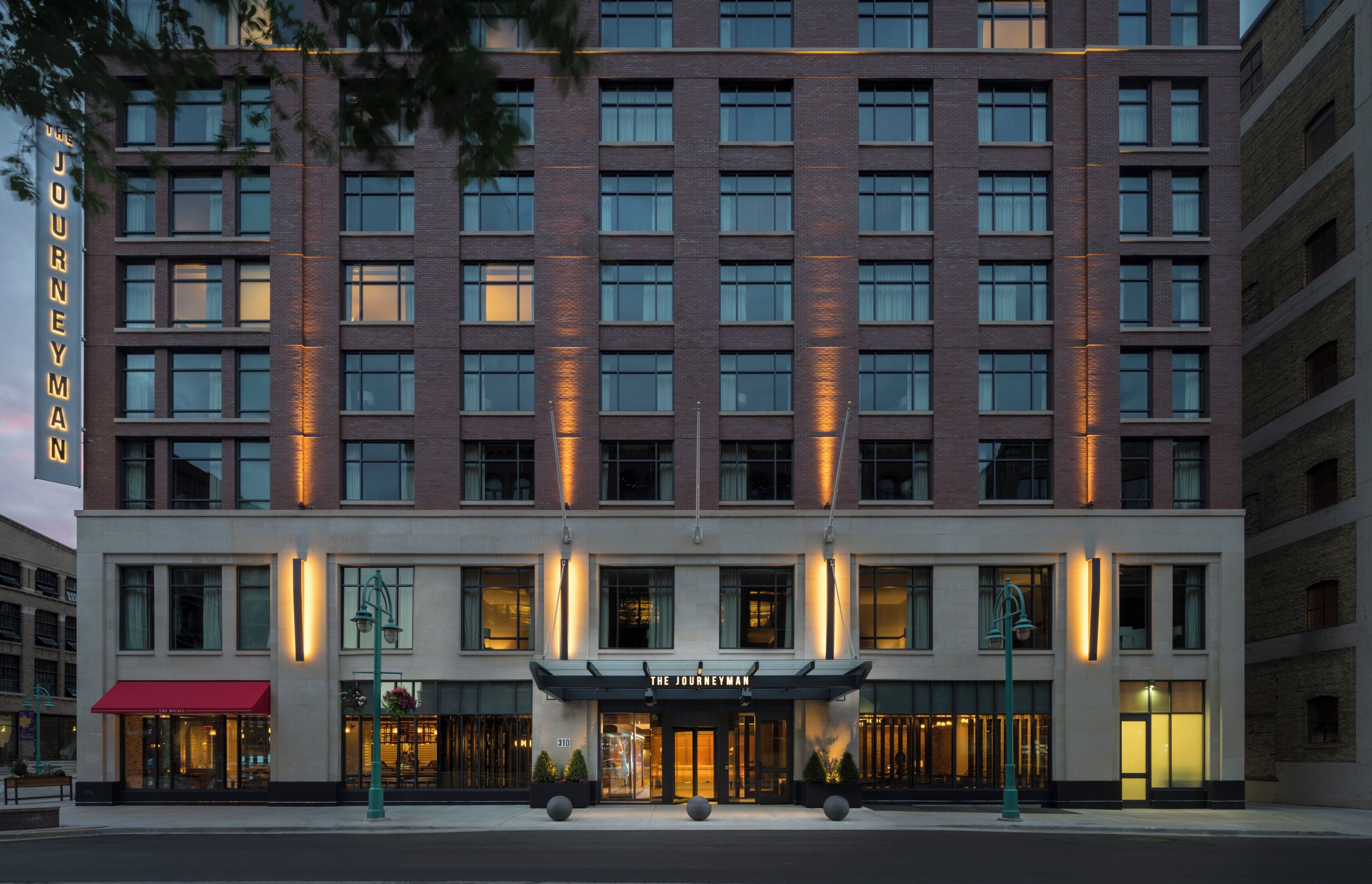 A multi-story hotel with a prominent entrance and a sign reading 'The Journeyman.'