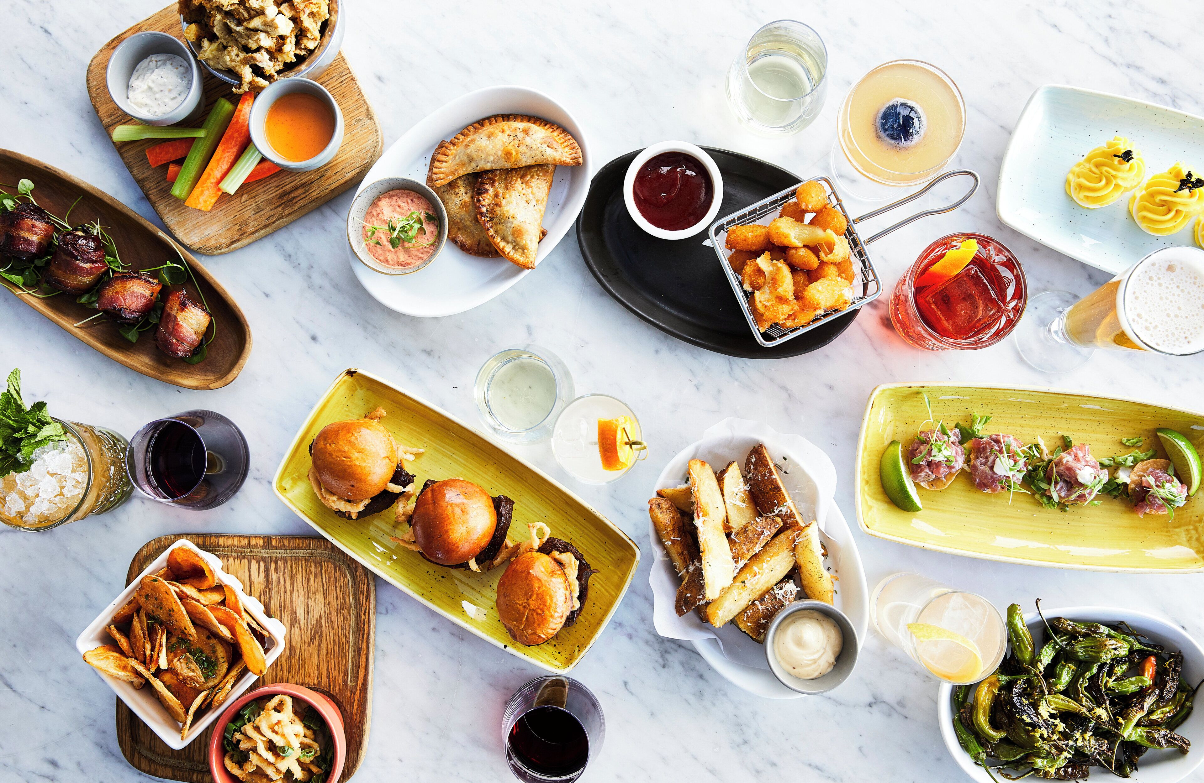 A variety of dishes and drinks on a marble table.