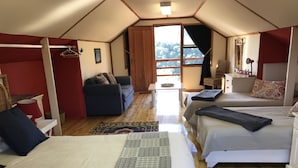 A cozy attic bedroom with two beds, a sofa, and a dining table. - The Carraighs (The Crags)