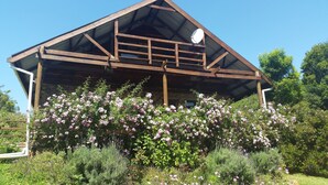 A rustic wooden building with a sloped roof and a satellite dish. - The Carraighs (The Crags)