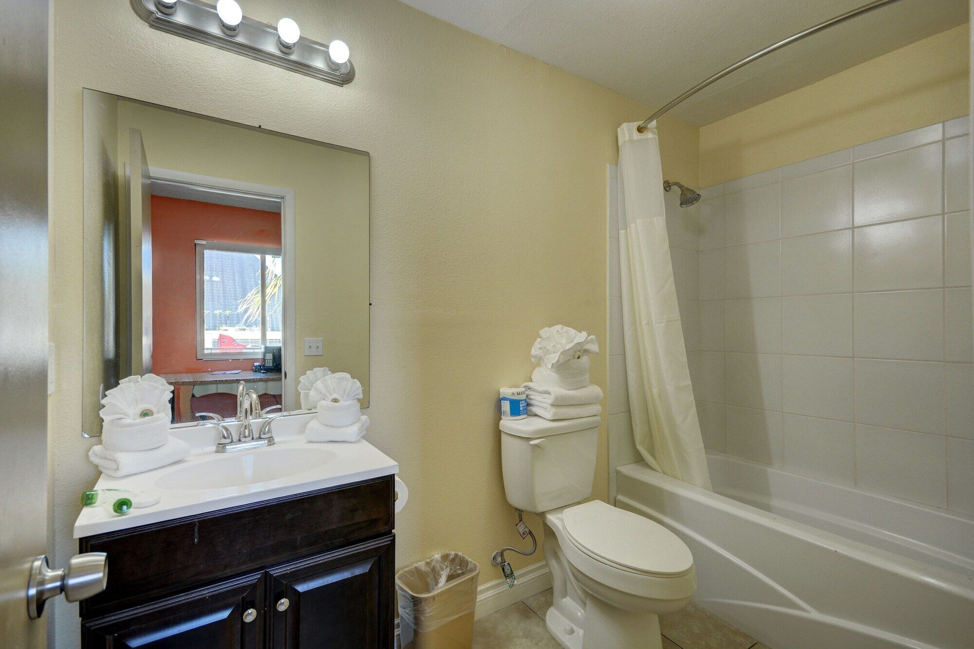 Ein Badezimmer mit Waschbecken, Spiegel, Toilette und Dusche.