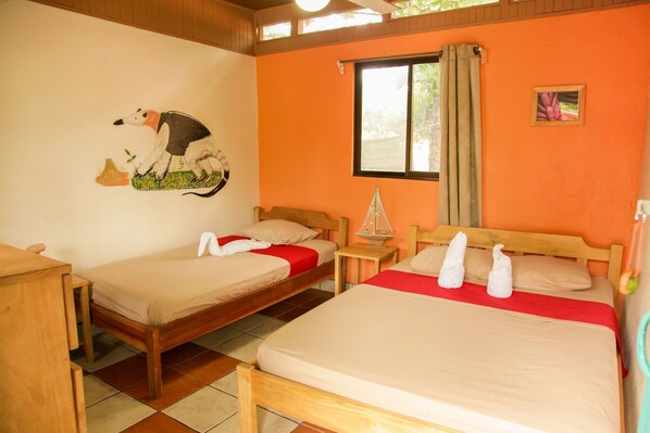 A room with two wooden beds, a small table, and a wall painting.