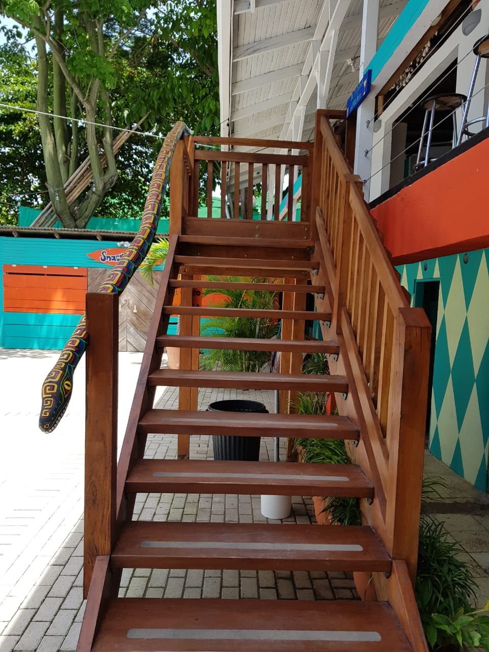 A wooden staircase with a handrail, leading to an upper level.