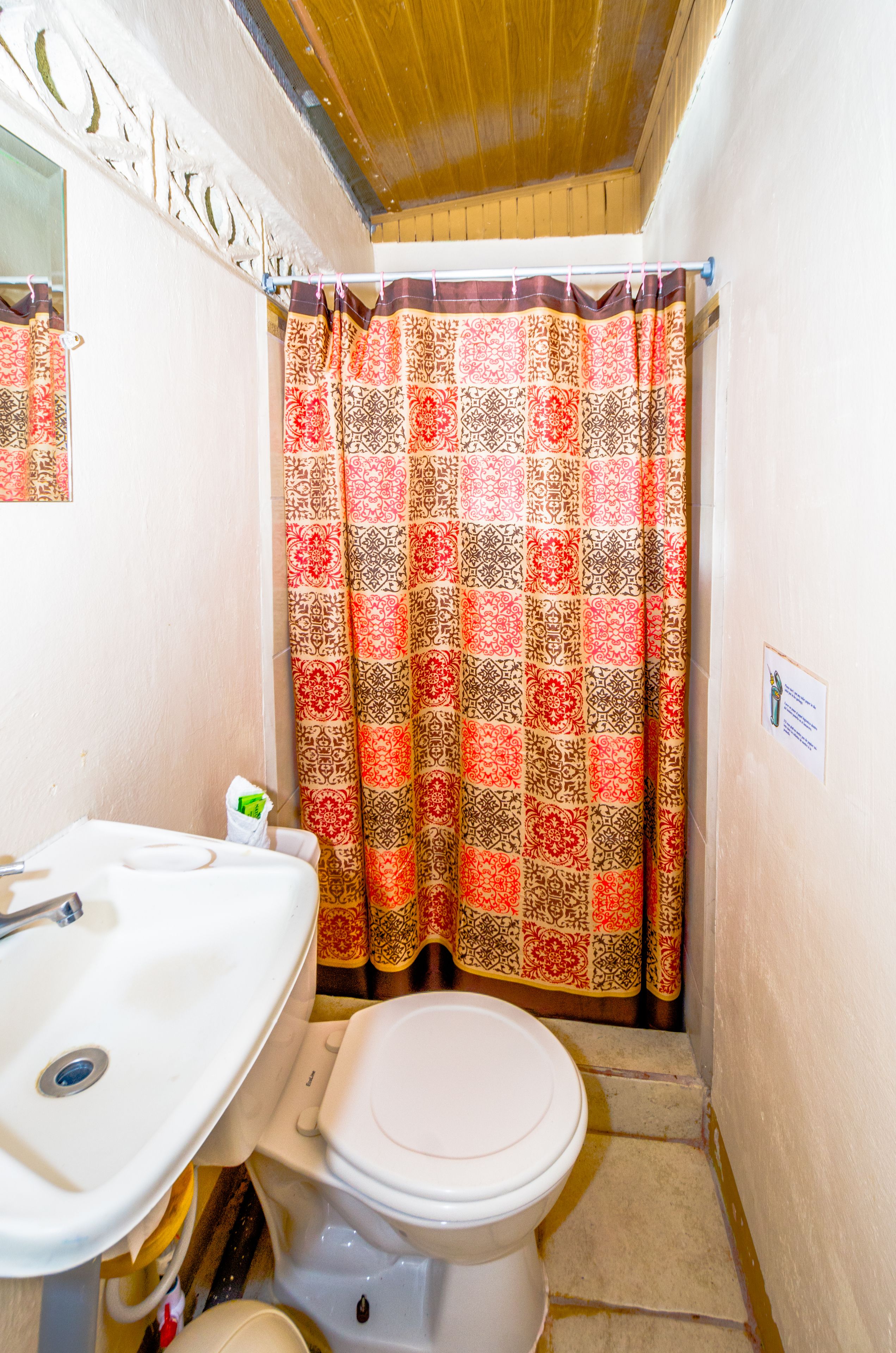 Ein kleines Badezimmer mit Toilette, Waschbecken und Duschvorhang.