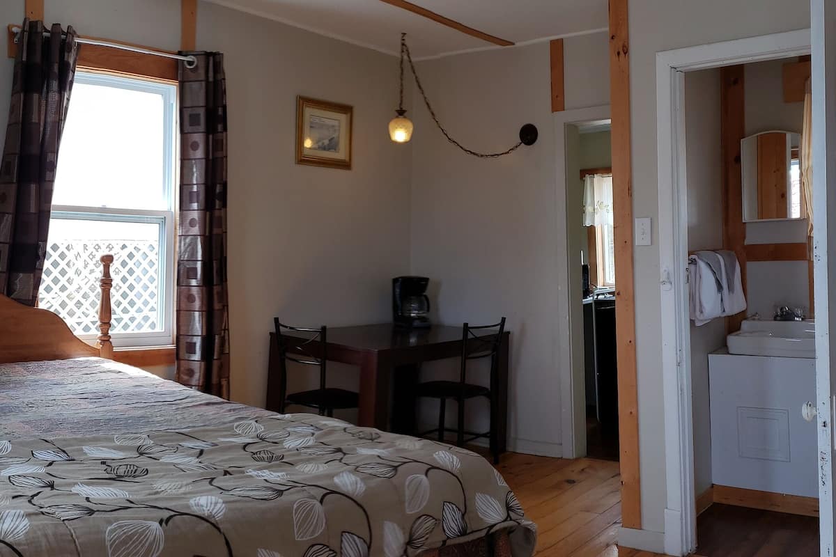 Ein Schlafzimmer mit Bett, Schreibtisch und Bad.