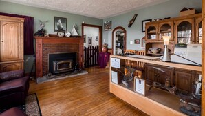 Ein traditionelles Wohnzimmer mit Kamin, Holzmöbeln und einer Vitrine.