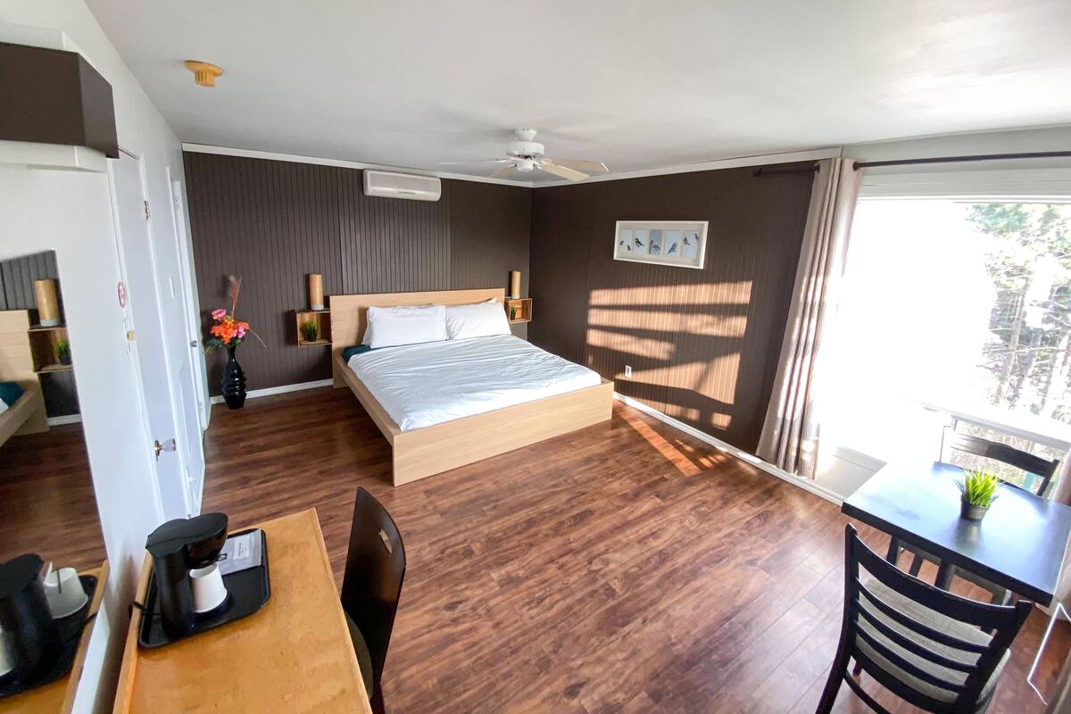 Ein Hotelzimmer mit Bett, Nachttischen, Schreibtisch und Stuhl.