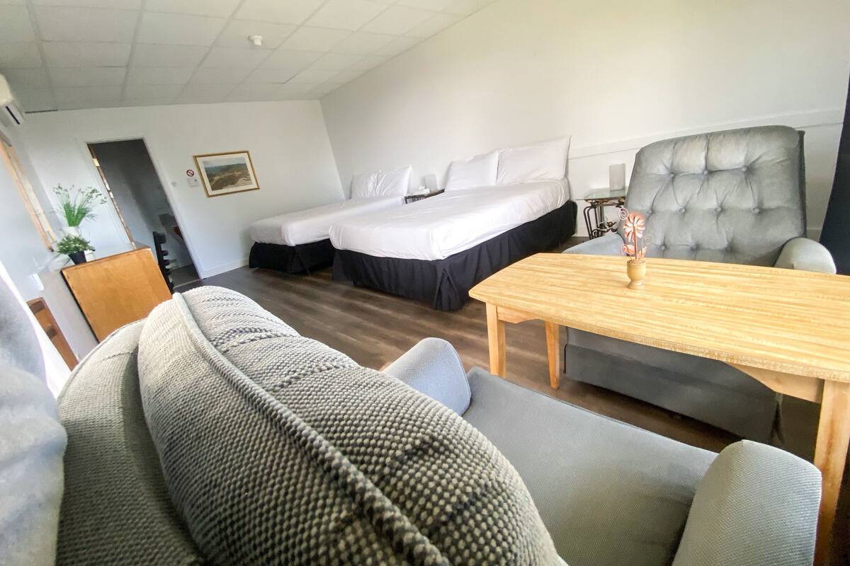 Ein Hotelzimmer mit Bett, Sofa, Esstisch und Stuhl.