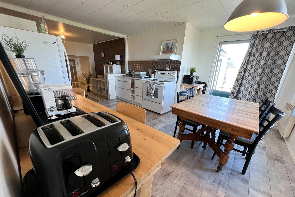 Eine moderne Küche mit integriertem Toaster, einem Esstisch mit Stühlen und Blick zum Wohnbereich.
