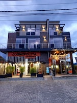 Un edificio moderno con un restaurante llamado 'COSMOPOLITA Restaurante' y un hotel llamado 'Ponteved'.