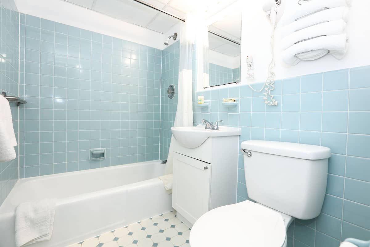 Ein Badezimmer mit Badewanne, Toilette, Waschbecken und blauen Fliesenwänden.