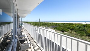 Un balcon avec des chaises et vue sur la plage.