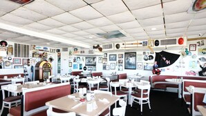 Un restaurant avec des banquettes et des tables, une décoration d’époque et une ambiance rétro.