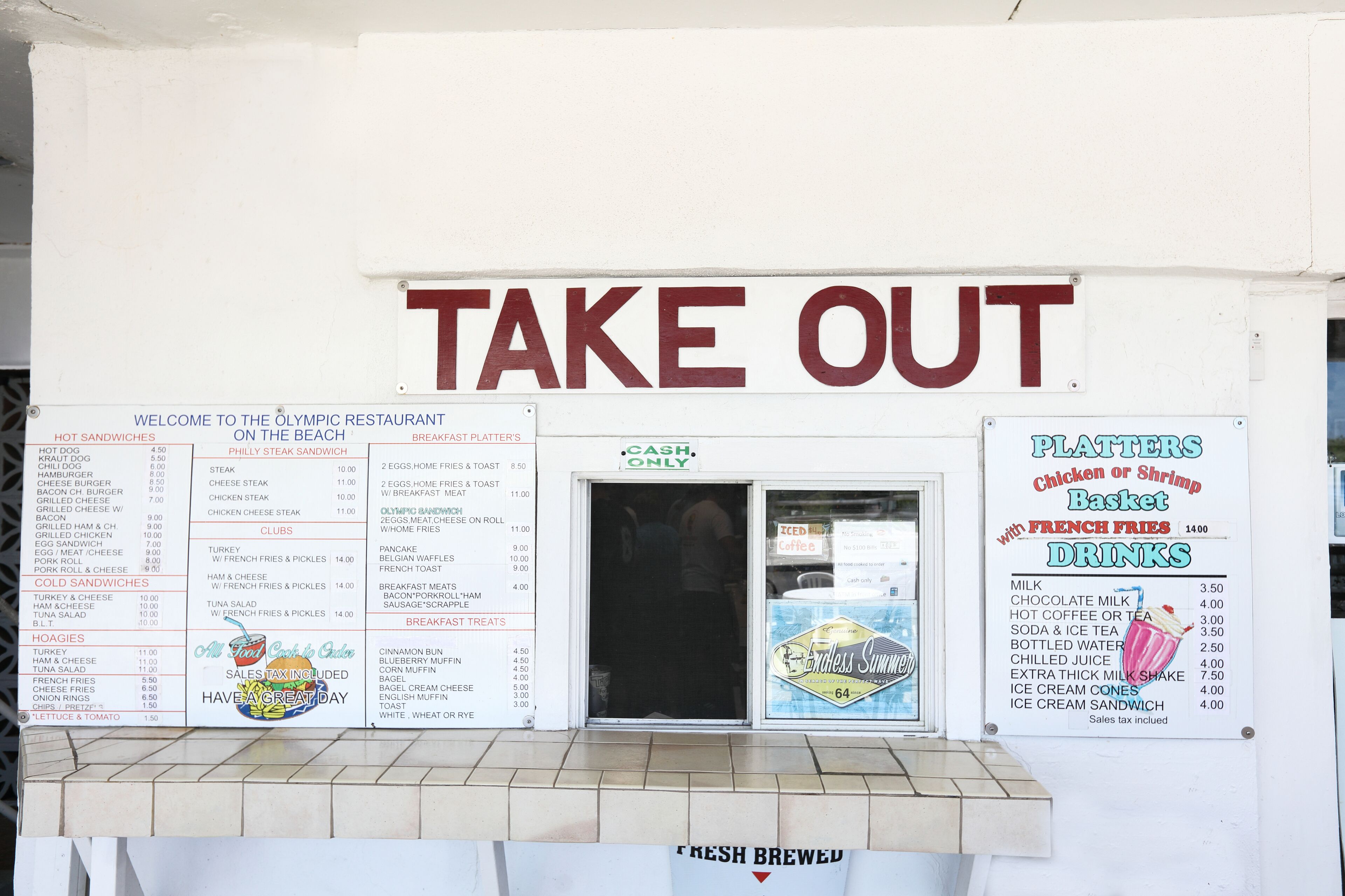 A restaurant with a 'TAKE OUT' sign, menu boards, and a 'CASH ONLY' payment option.