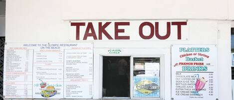 A restaurant with a 'TAKE OUT' sign, menu boards, and a 'CASH ONLY' payment option.