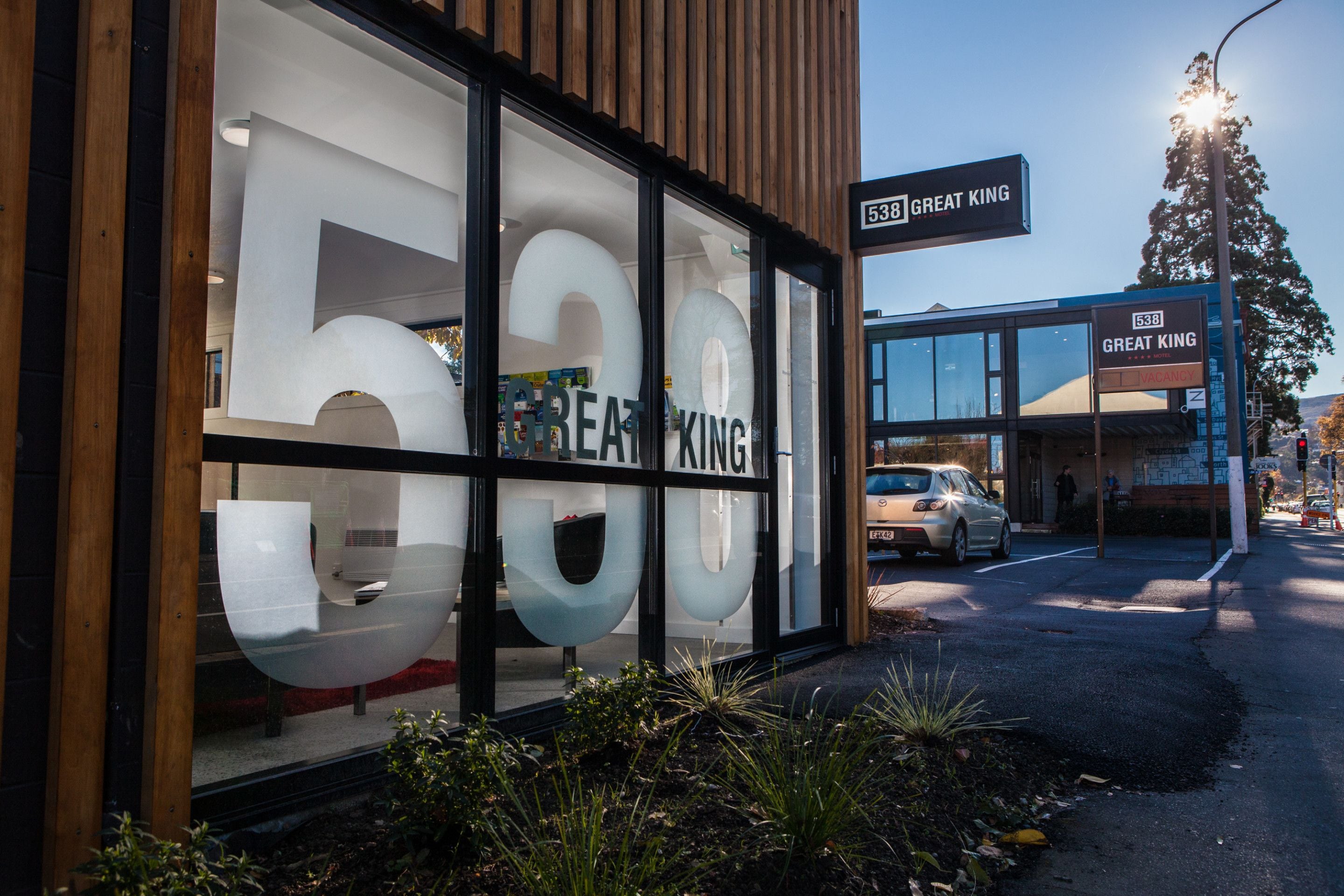 Un bâtiment doté de grandes fenêtres en verre sur lesquelles on peut voir le numéro 538 et le nom « GREAT KING ».