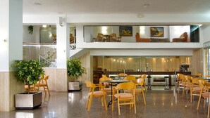 Un vestíbulo amplio con una zona de estar central, una escalera y un bar.