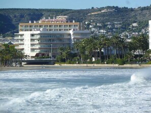 A hotel with multiple floors, balconies, and a view of the beach and ocean. - Hotel Villa Naranjos (Javea)