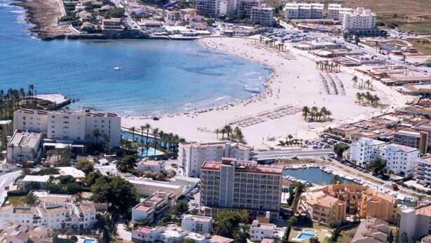 Un pueblo costero con playa, hoteles y puerto deportivo.