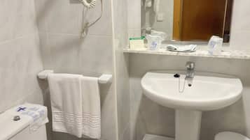 Een badkamer met toilet, wastafel en handdoekrek.