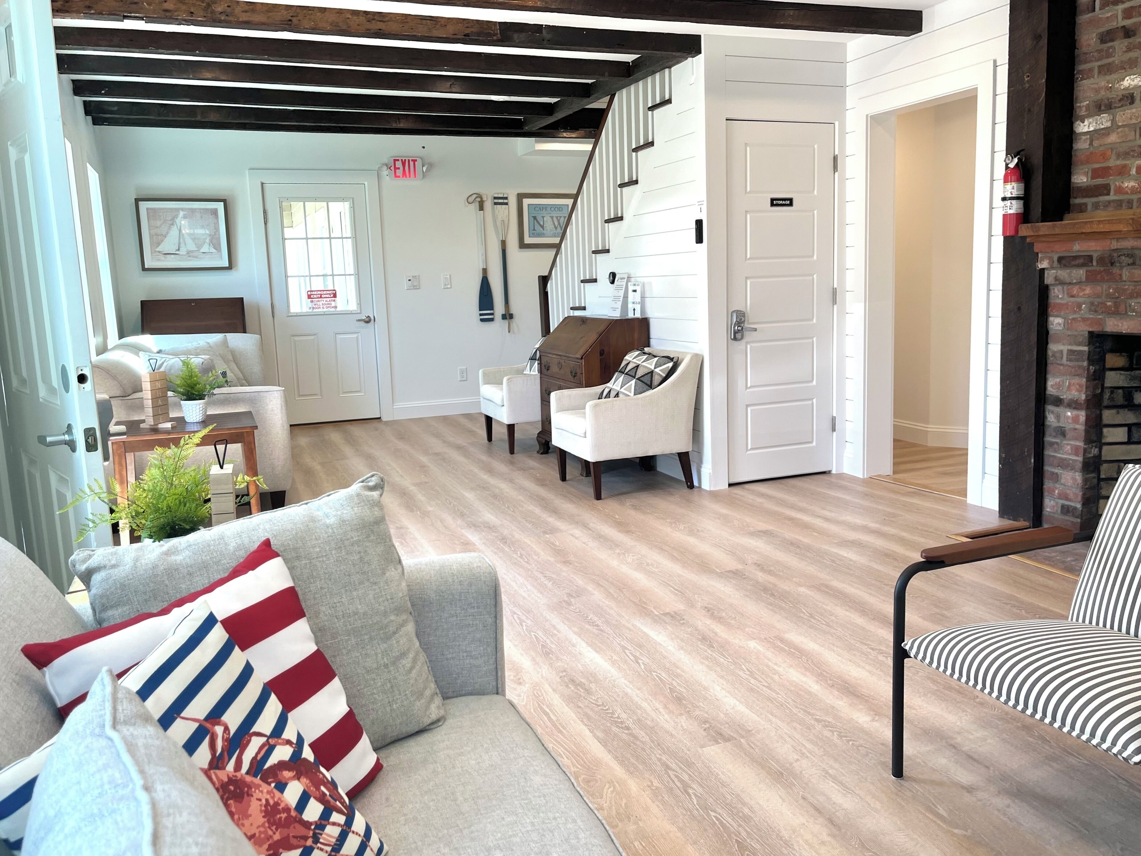 Un salon spacieux doté d’un plancher en bois, d’un escalier et d’une cheminée.