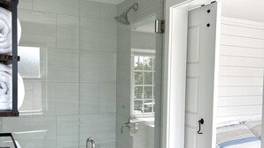 Une salle de bain moderne avec une douche à parois de verre, un lavabo blanc et un porte-serviettes.