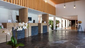 A spacious lobby with a reception desk, wooden ceiling, stone flooring, and hanging pendant lights. - El Mirador de Fuerteventura (Puerto del Rosario)