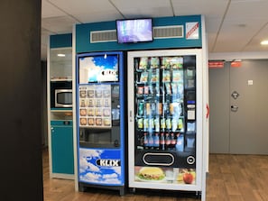 A vending machine with a variety of snacks and drinks, including chips and soda.