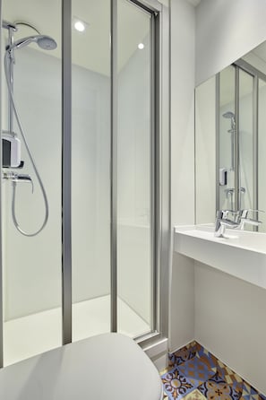 A modern bathroom with a glass shower enclosure, a white sink, and a mirror. - hotelF1 Paris Gennevilliers (Gennevilliers)