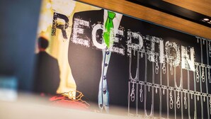 Een receptiezone met een groot bord, een houten plafond en een onscherpe achtergrond.