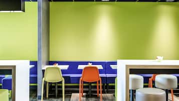 A restaurant with booths and high tables, some with stools.
