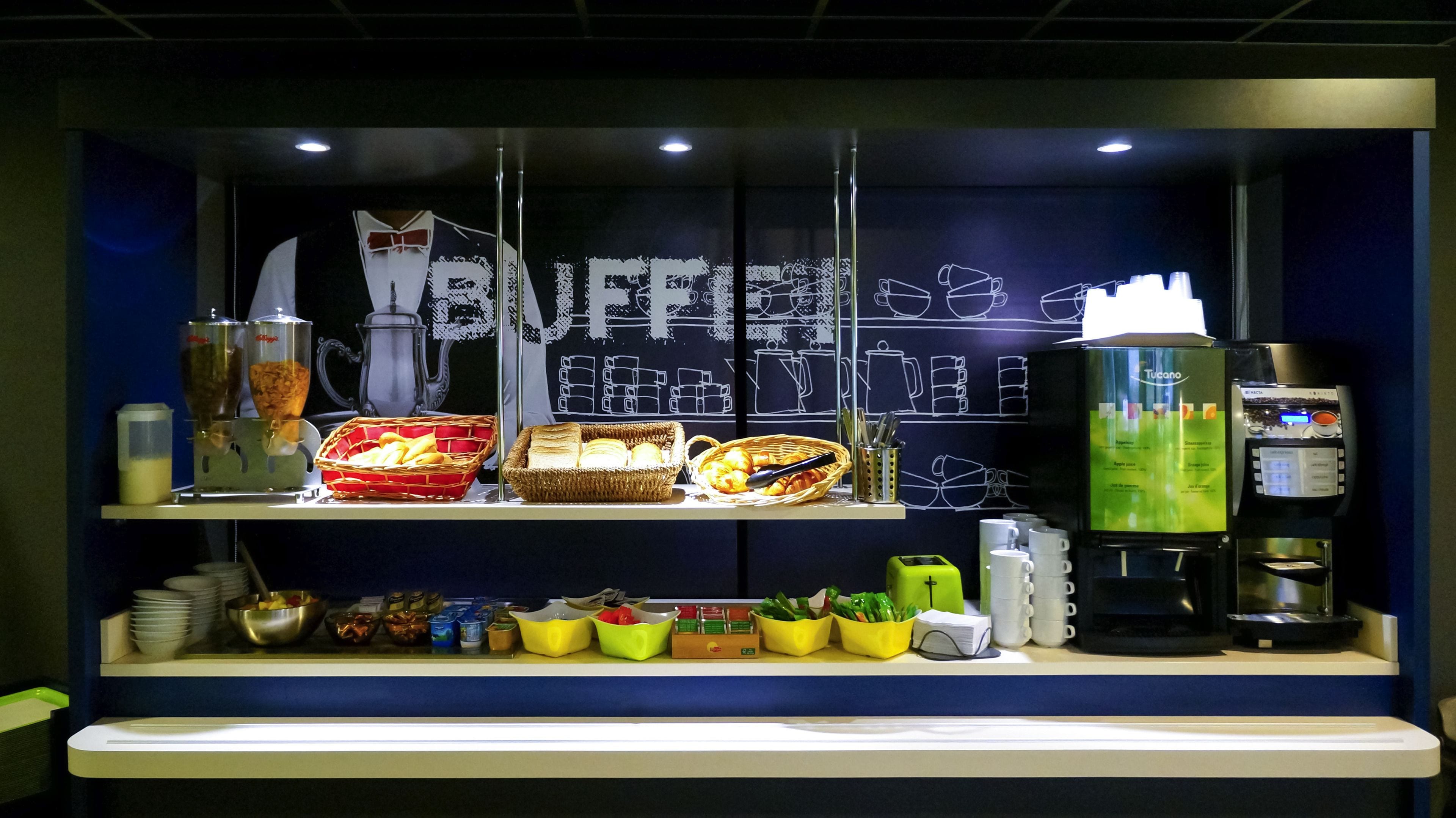 Un buffet proposant divers plats, une machine à café et un menu écrit à la craie.