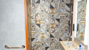Une salle de bain équipée de toilettes, d’un lavabo, d’un miroir et de carreaux décorés.